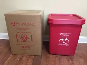 Red Bag Setup A cardboard SecureStream medical waste box next to a red plastic biohazard container.