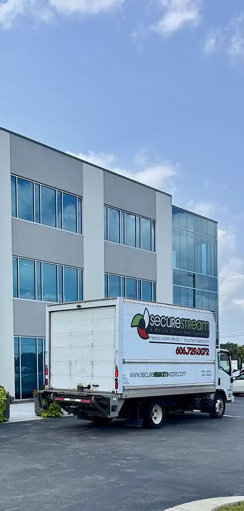 A white SecureStream box truck parked in front of a modern grey office building.